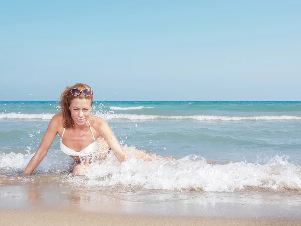 Młoda kobieta relaksująca się na plaży — Zdjęcie stockowe