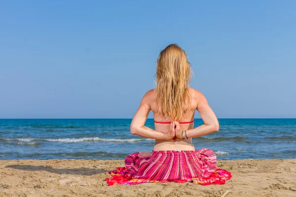 Mujer practicando yoga en la playa — Foto de Stock