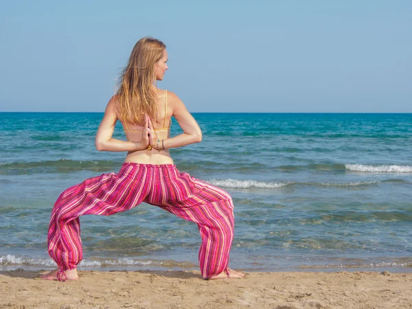 Kobieta praktykująca jogę na plaży — Zdjęcie stockowe