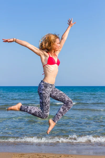 Vrouw oefenen yoga op het strand — Stockfoto