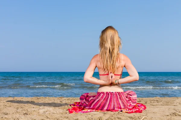 Vrouw oefenen yoga op het strand — Stockfoto