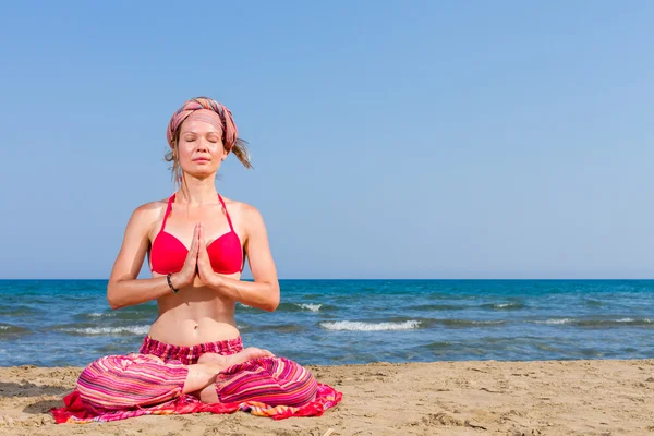 Mujer practicando yoga en la playa — Foto de Stock