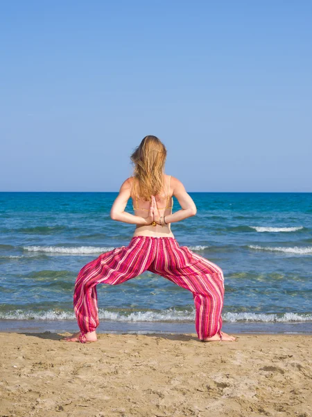 Kobieta praktykująca jogę na plaży — Zdjęcie stockowe