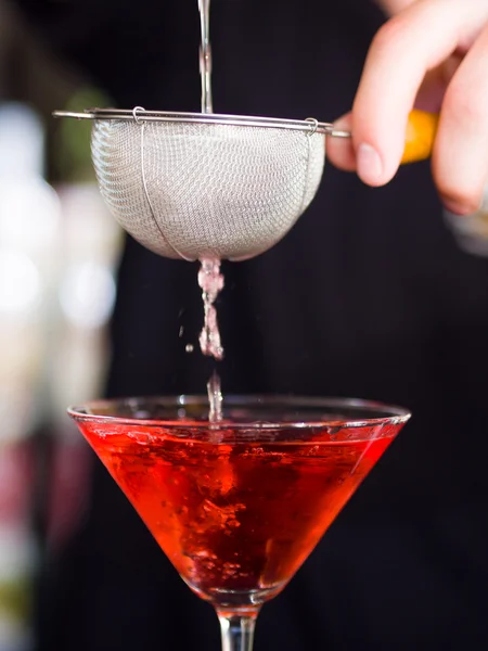 Bartender pooring cocktail into Martini glass — Stock Photo, Image