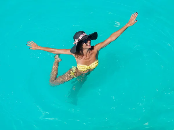 Une fille se relaxe dans une piscine — Photo