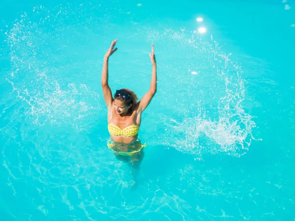 Uma menina está relaxando em uma piscina — Fotografia de Stock