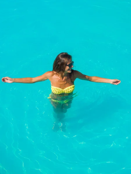 Une fille se relaxe dans une piscine — Photo