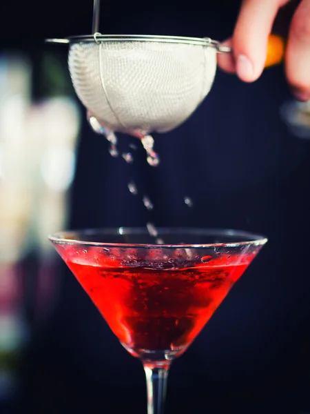 Bartender pooring cocktail into Martini glass — Stock Photo, Image