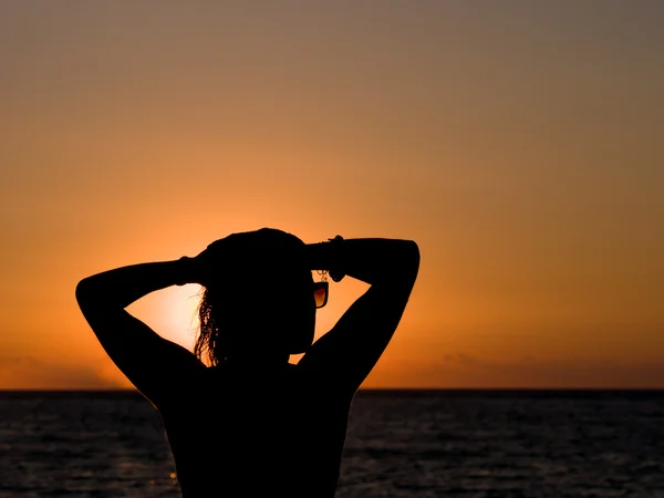 Силуэт женщины, стоящей на пляже — стоковое фото