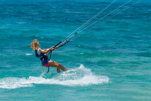 Mladá žena kite surfaře jízdy v zeleno modré moře — Stock fotografie