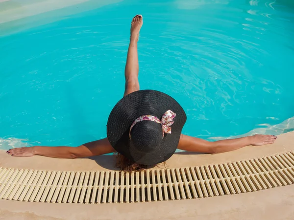 Uma menina está relaxando em uma piscina — Fotografia de Stock