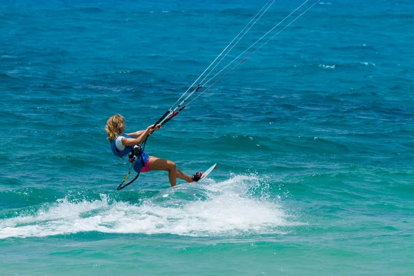 Een jonge vrouw kite-surfer rijdt in groenig-blauwe zee — Stockfoto