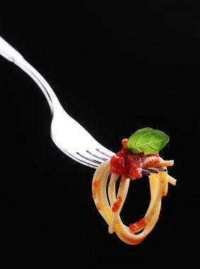 Spaghetti on a fork with tomato sauce