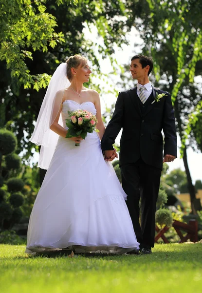 Jeune couple de mariage marchant heureux en plein air — Photo