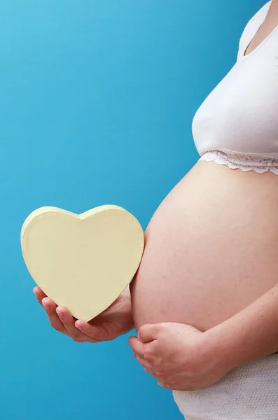 Ventre de femme enceinte avec le coeur — Photo