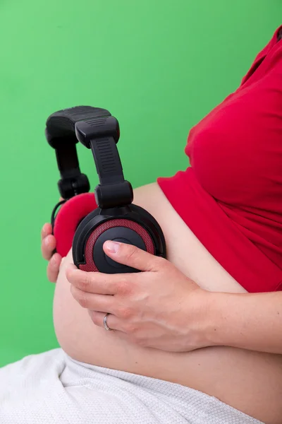 Zwangere vrouw met hoofdtelefoon — Stockfoto