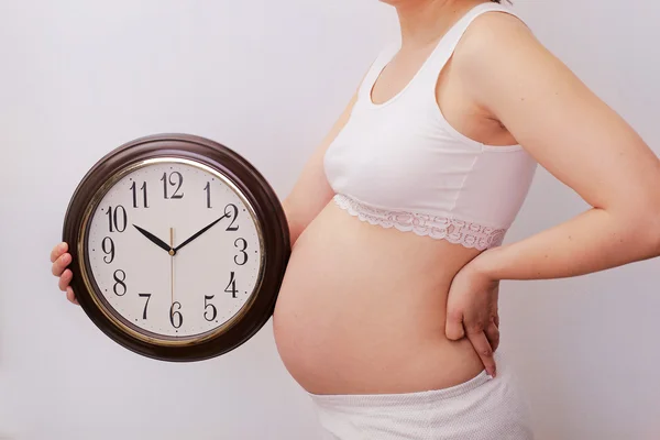 Pregnant woman with clock — Stock Photo, Image
