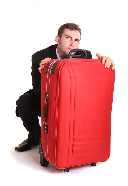 Distrustful business man behind red luggage — Stock Photo, Image