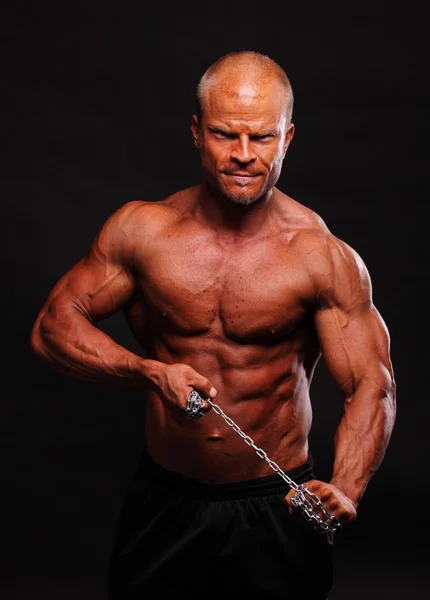 Gespierde bodybuilder man met een keten — Stockfoto