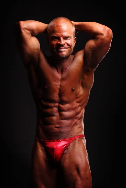 Muscular male bodybuilder posing in studio — Stock Photo, Image