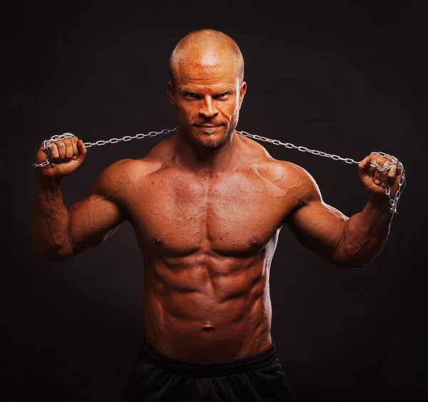 Gespierde bodybuilder man met een keten — Stockfoto