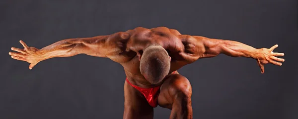 Muskulös man med utsträckta armar till sidan och huvudet ner — Stockfoto
