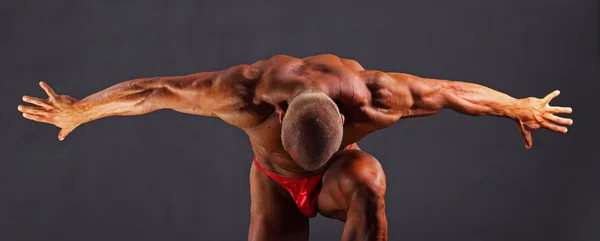 Muscular man with outstretched arms to the side and his head down — Stock Photo, Image