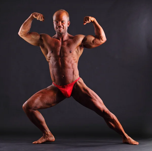 Bodybuilder beugt Bizeps vor — Stockfoto