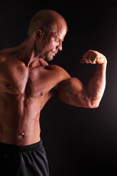 Bodybuilder muskelbygge biceps — Stockfoto