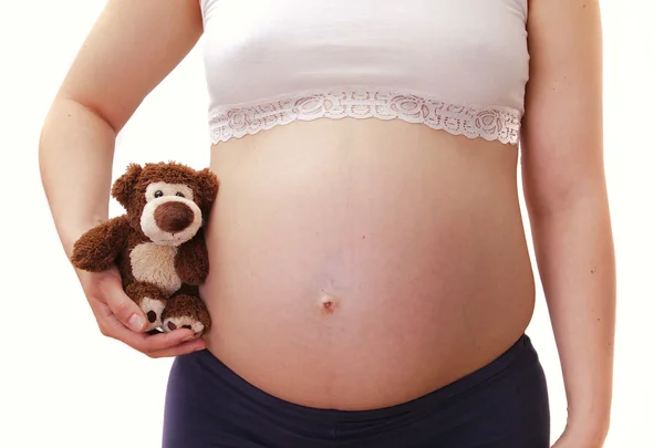 Mujer embarazada sosteniendo oso de peluche — Foto de Stock