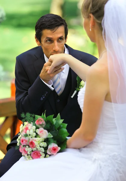 Young groom gives kiss for hand