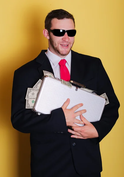 Biznes człowiek posiada walizkę z pełną pieniędzy notatki — Zdjęcie stockowe