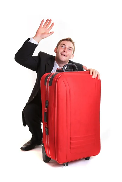 Young man raise up one's hand behind red luggage — Stock Photo, Image