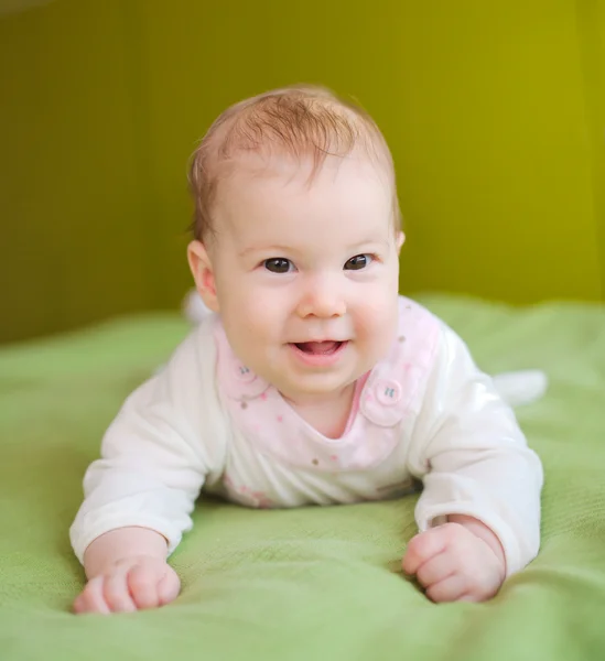 Lindo bebé sonriente acostado en la cama — Foto de Stock