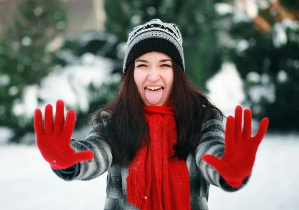 Junge schöne Frau zeigt ihre verschneite Palme im Winter — Stockfoto