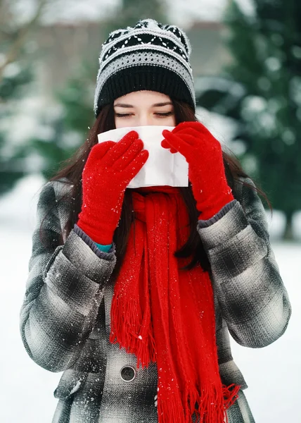 Joven hermosa mujer al aire libre soplado nariz en invierno —  Fotos de Stock