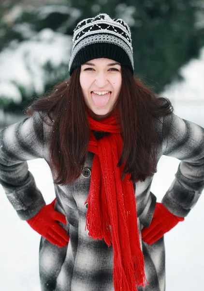 Jonge mooie vrouw buiten iemands tong stak in de winter — Stockfoto