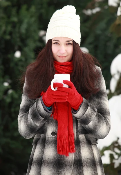 Woman holding hot coffee or tea outdoors in winter — Stockfoto