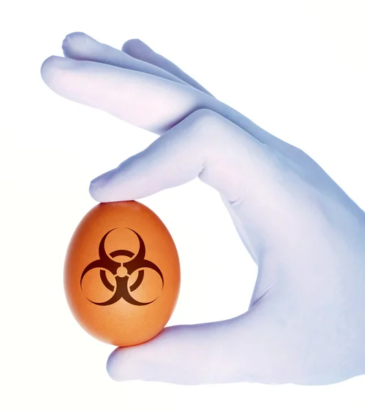 Biyolojik tehlike sembolü ile yumurta tutan el — Stok fotoğraf