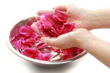 Elinde bir demet pembe yaprak ve kase