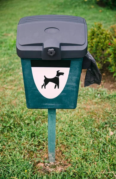 Green dog waste bin with plastic outdoor in park