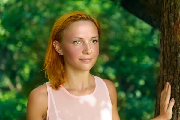 Young woman standing near tree — Stock Photo, Image