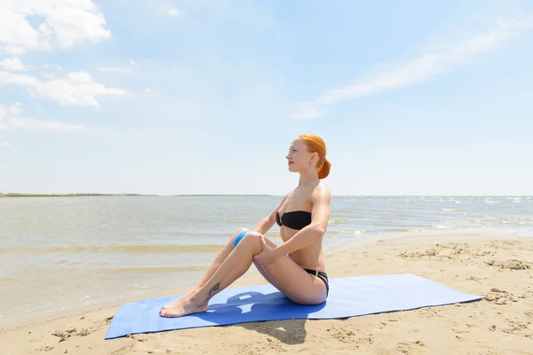 Krásná žena cvičí fitness u moře — Stock fotografie