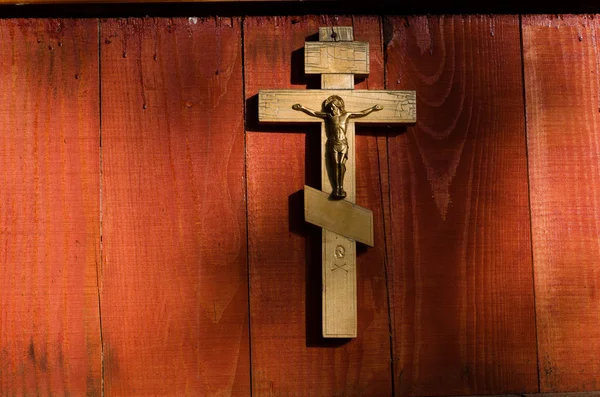 Pequeno crucifixo de madeira pendurado na parede — Fotografia de Stock