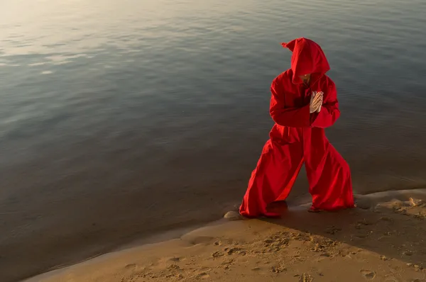 Карате-монах в красном капюшоне медитирует — стоковое фото
