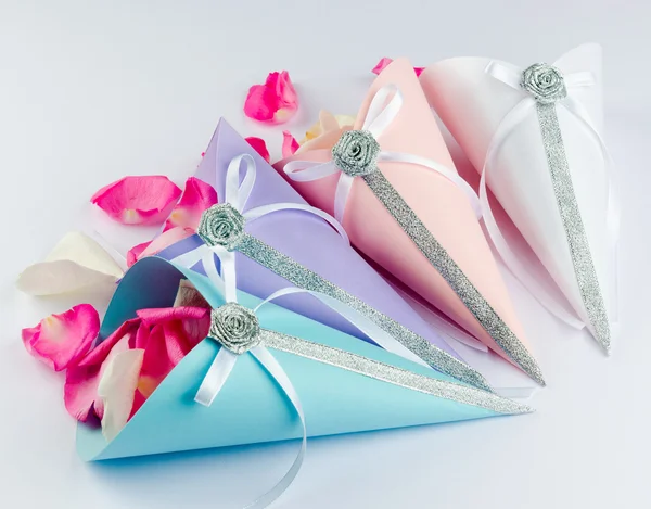 Pétalos de rosa en conos de confeti con lazos de cinta de satén — Foto de Stock