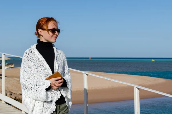 Ung kvinde på stranden på en kold dag - Stock-foto