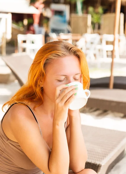 Giovane donna che beve caffè in spiaggia — Foto Stock