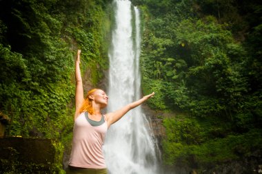 pratik Yoga şelale ile genç bir kadın