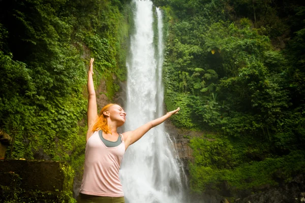 pratik Yoga şelale ile genç bir kadın